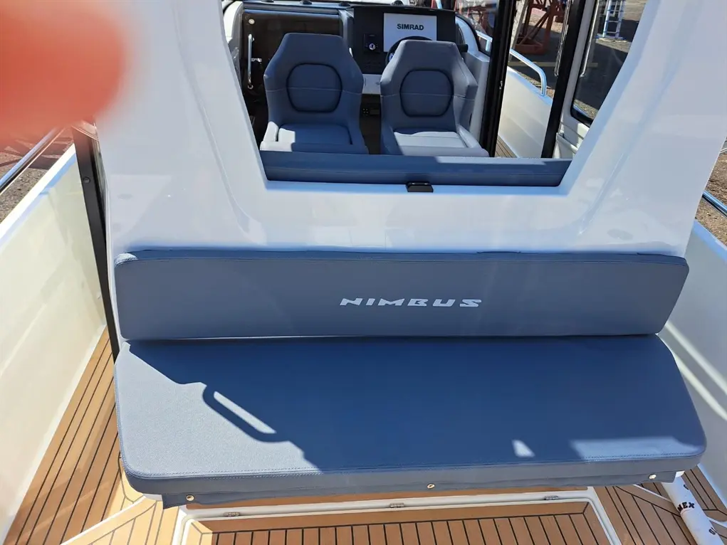 Interior of a Nimbus boat showing grey seating, featuring the brand name 'NIMBUS' and a dashboard in the background.